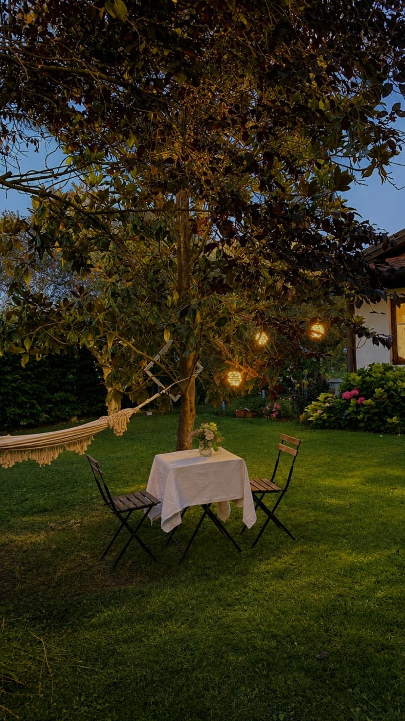 Tavolo apparecchiato in giardino con luci al tramonto